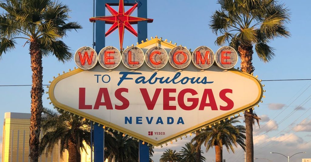 Famous Las Vegas Welcome sign surrounded by palm trees at sunset.